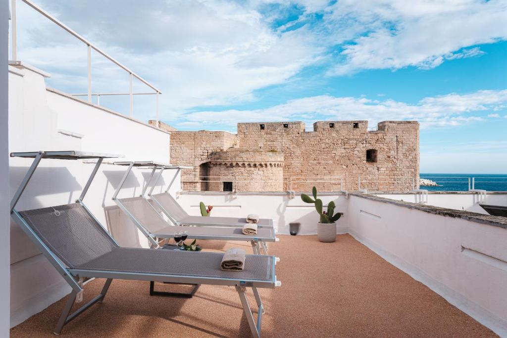 un balcón con 2 sillas y un castillo en Sea View Romantic Apartments Al Vecchio Porto, en Monopoli