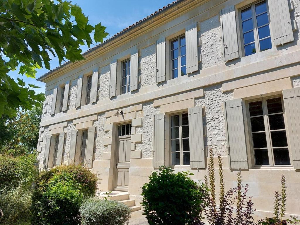 - un vieux bâtiment en pierre avec des fenêtres à volets dans l'établissement Maison de Charme, à Saint-Georges-des-Agoûts