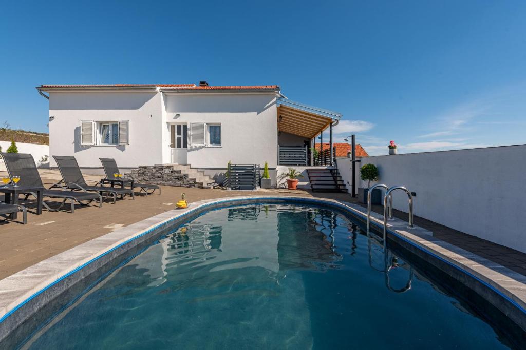 a swimming pool in front of a house at Villa Sea Pearl ZadarVillas in Maslenica
