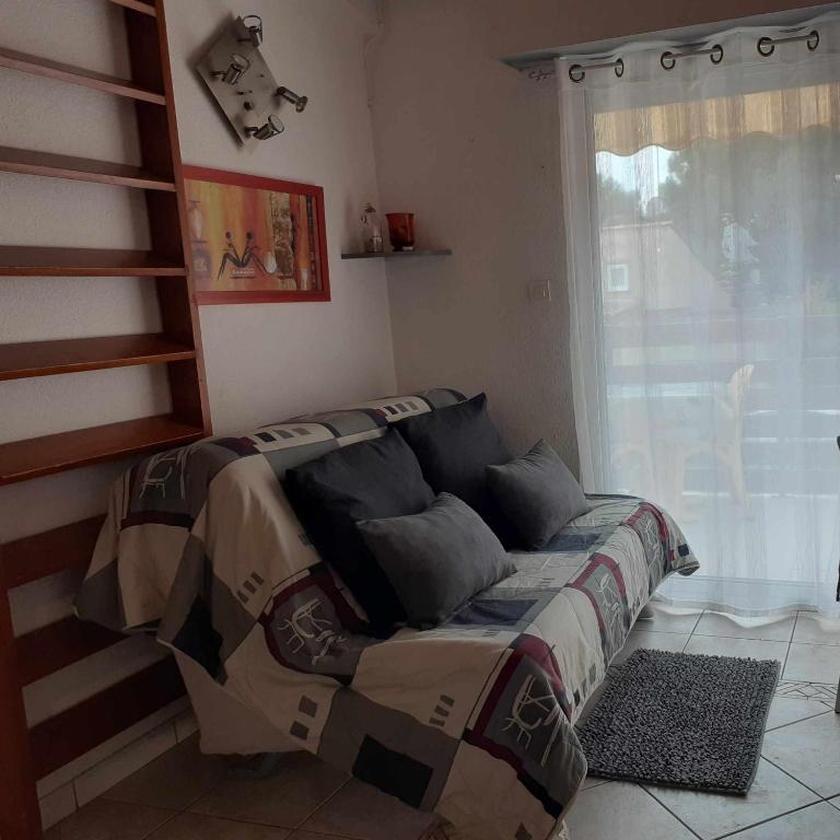 un lit assis dans une pièce avec une fenêtre dans l'établissement Le Cap'tivant, au Cap d'Agde