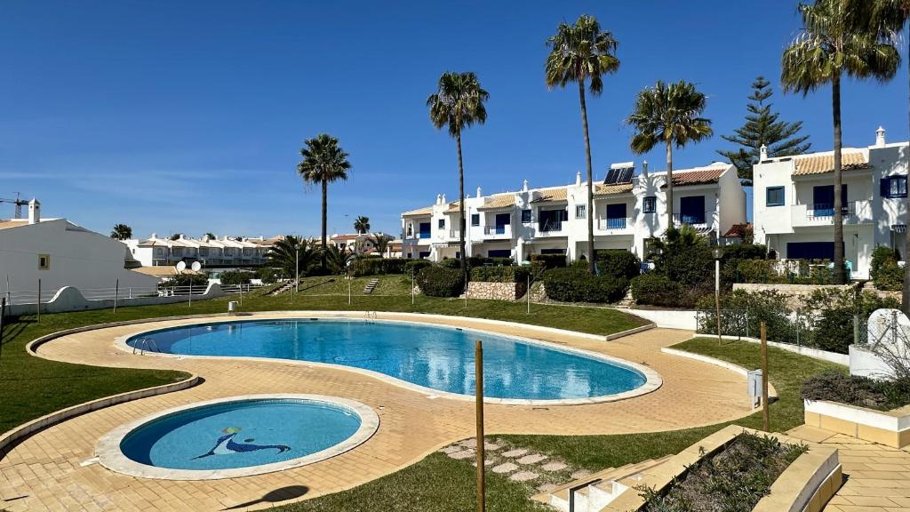 ein Swimmingpool in einem Resort mit Palmen in der Unterkunft Jardim da Oura 2 by Check-in Portugal in Albufeira