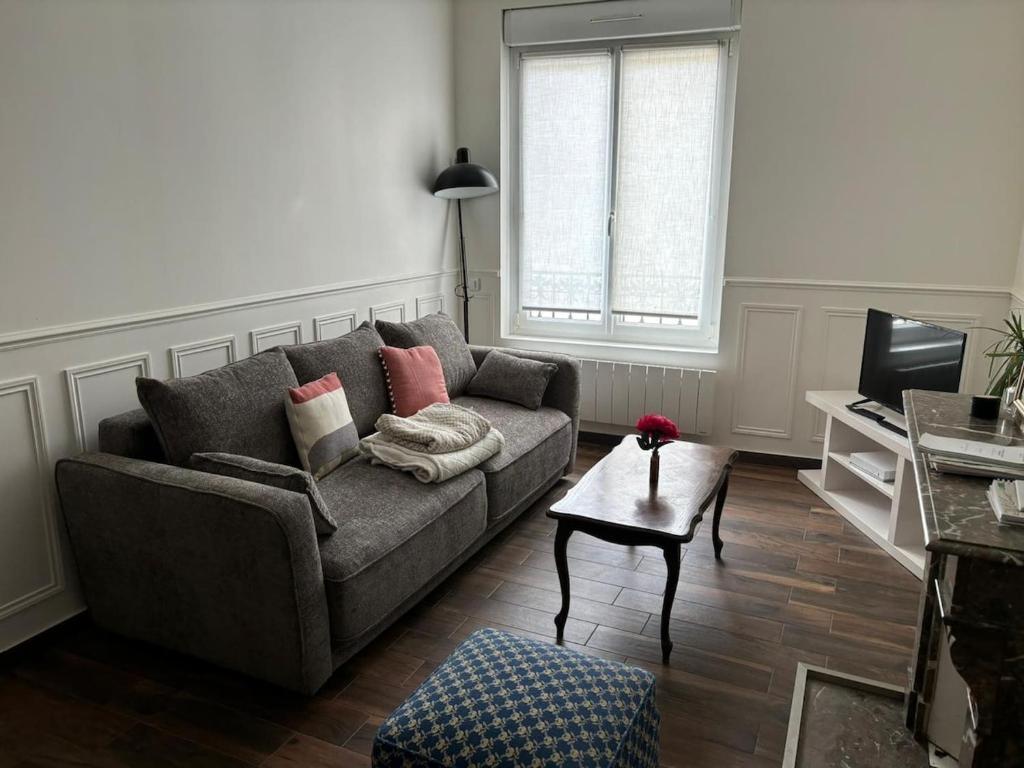 un salon avec un canapé et une table dans l'établissement Orlando - Cocon Haussmanien en centre-ville, à Reims