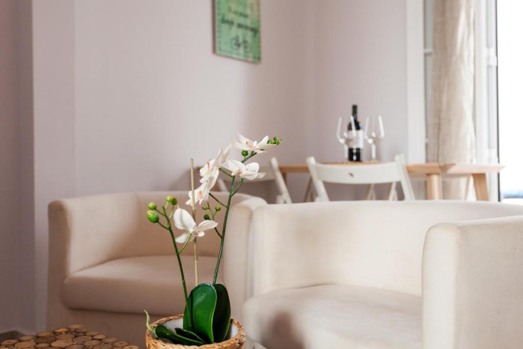 un jarrón con flores blancas sobre una mesa en la sala de estar en Acogedor y central, en Sevilla