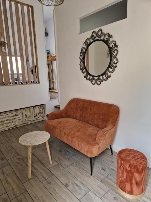 - un salon avec un canapé brun et un miroir dans l'établissement La Baraquette de Thau, à Mèze