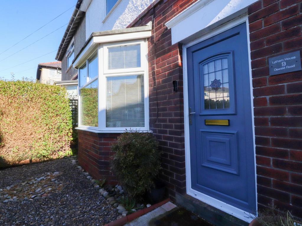 a blue door on the side of a brick house at Lytham House in Lytham St Annes
