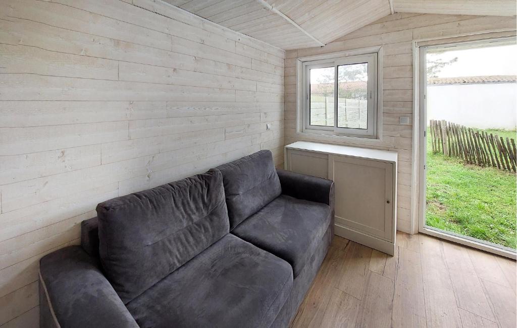 a leather couch in a room with a window at Awesome Home In Barbatre in Barbâtre