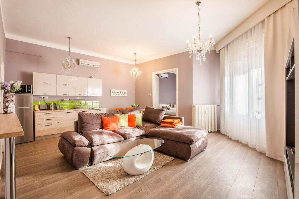 ein Wohnzimmer mit einem Sofa und einem Tisch in der Unterkunft Two Couples Apartment in Budapest