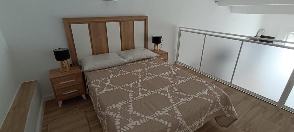 ein Schlafzimmer mit einem Bett und einem Nachttisch in der Unterkunft Apartamento VILLASUR in Alcalá de los Gazules