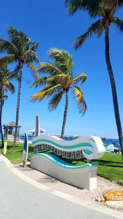 a large inflatable boat on the beach with palm trees at BEACH Zen Oasis-walk 2 beaches in Deerfield Beach