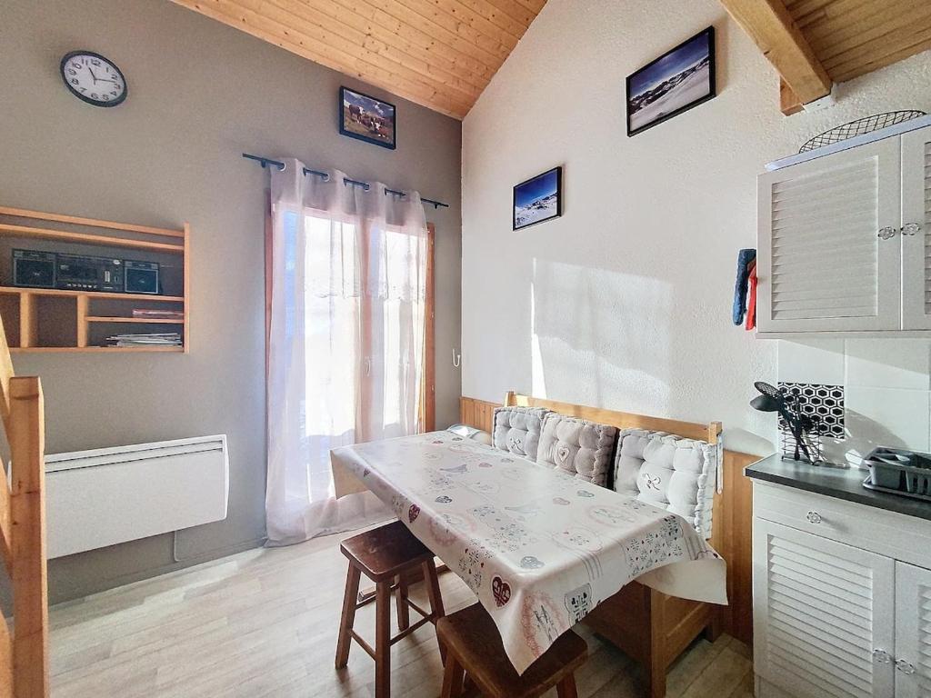 een keuken met een tafel en stoelen en een raam bij Charming duplex in La Toussuire