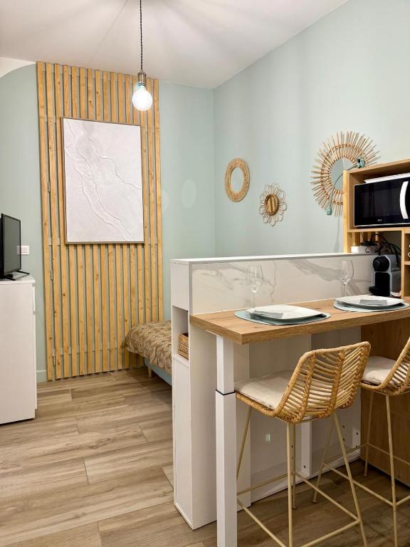 - une cuisine avec une table et un four micro-ondes dans l'établissement Le cocon du Roi Jérôme - Hypercentre, à Ajaccio