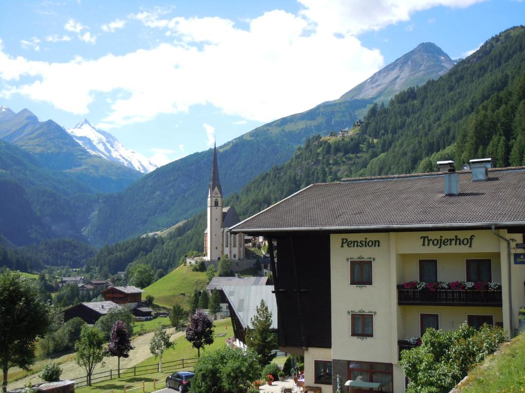 a town in a valley with a church and mountains at Pension Trojerhof in Heiligenblut