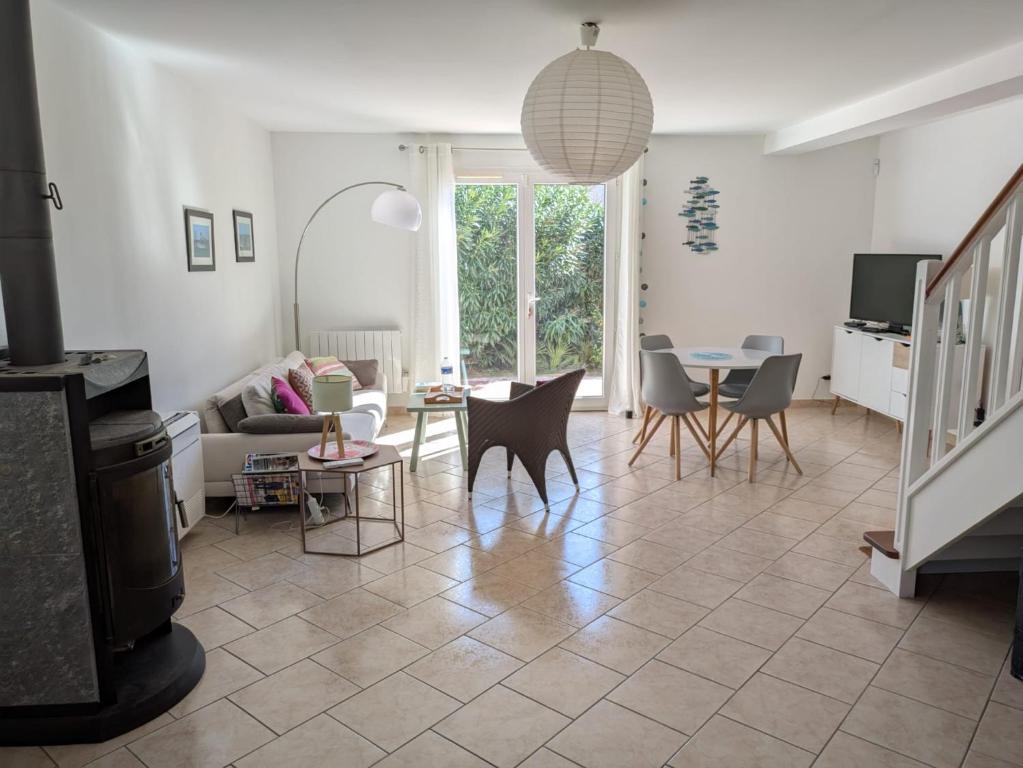 un salon avec un canapé et une table dans l'établissement Maison proche mer - 5 couchages - ideal planchistes, à Lapalme