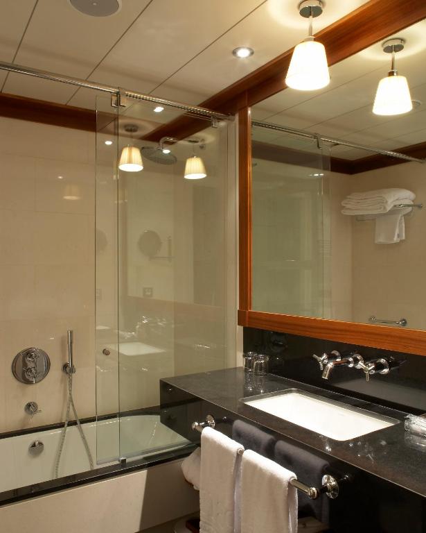 a bathroom with a shower and a sink and a mirror at Hotel 1898 in Barcelona