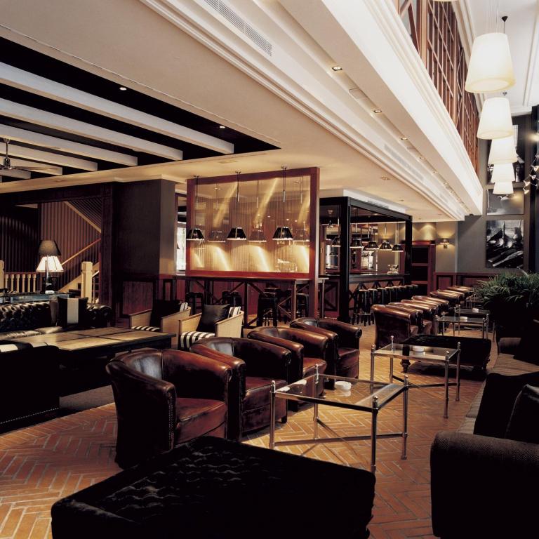 a lobby with couches and chairs and tables at Hotel 1898 in Barcelona