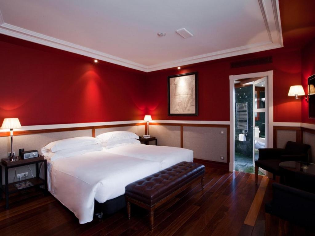 a bedroom with a white bed and red walls at Hotel 1898 in Barcelona