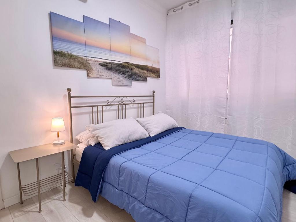 a bedroom with a blue bed and a table with a lamp at La Casa Di Giorgio in Sanremo