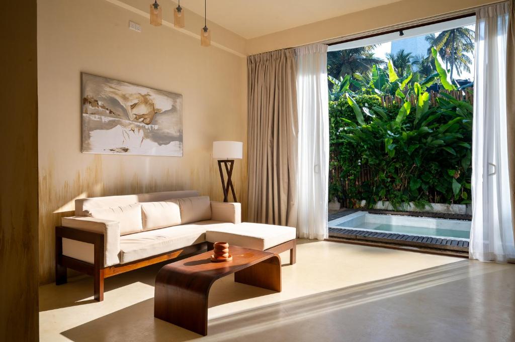 a living room with a couch and a large window at Triton Dondra in Dondra West