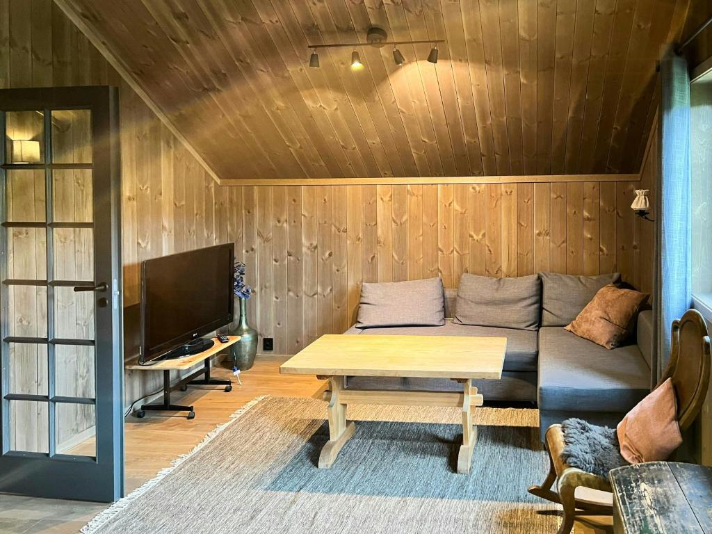 a living room with a couch and a table at Modern Family Cabin At Vegglifjell in Veggli