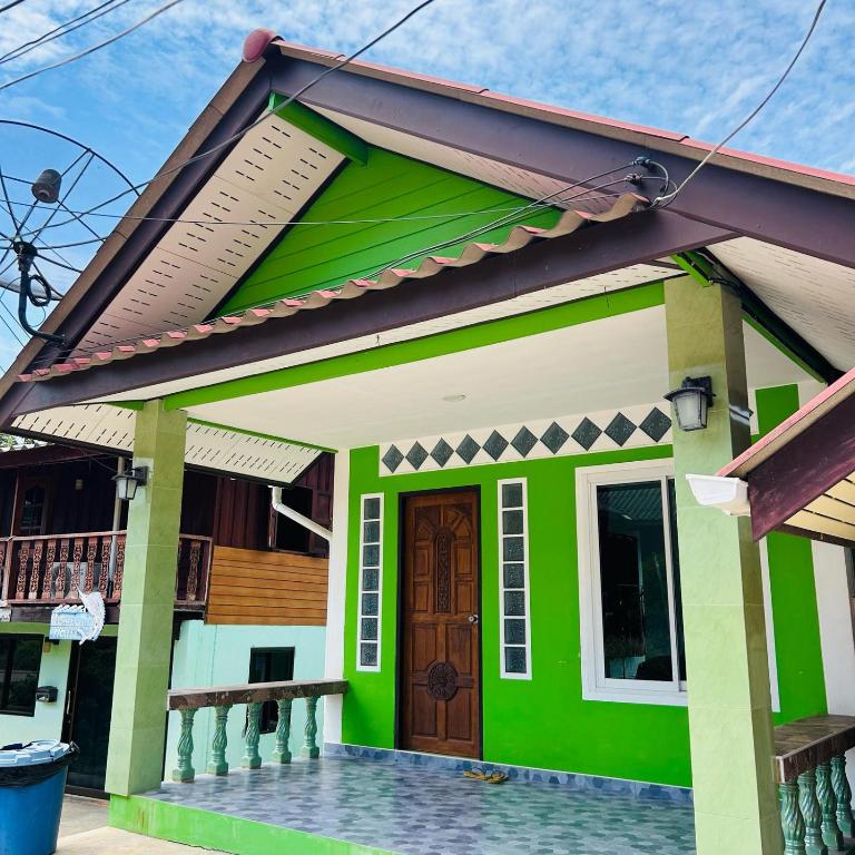 a green house with a red roof at Lamsai AC Sea House Green in Ko Yao Noi