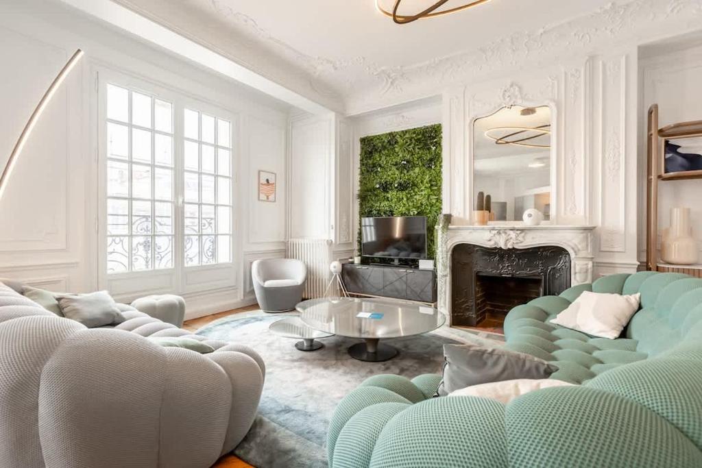 un salon avec un canapé et une cheminée dans l'établissement Keyz - Luxury 3 Bedrooms near Champs Elysees, à Paris