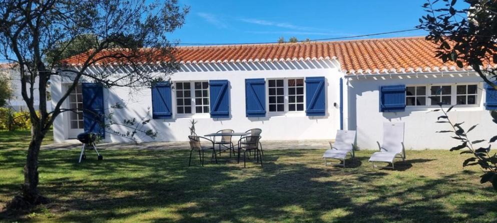 une maison avec des chaises et une table dans la cour dans l'établissement Maison à 250m de la mer au calme sous les pins, à Bretignolles-sur-Mer