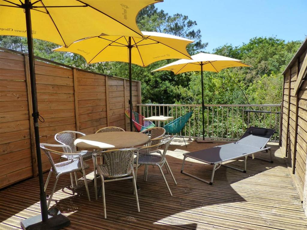a table and chairs with umbrellas on a deck at HOSSEGOR Entre lac et océan Résidence LES DUNES, villa patio pour 4 à 5 personnes in Hossegor