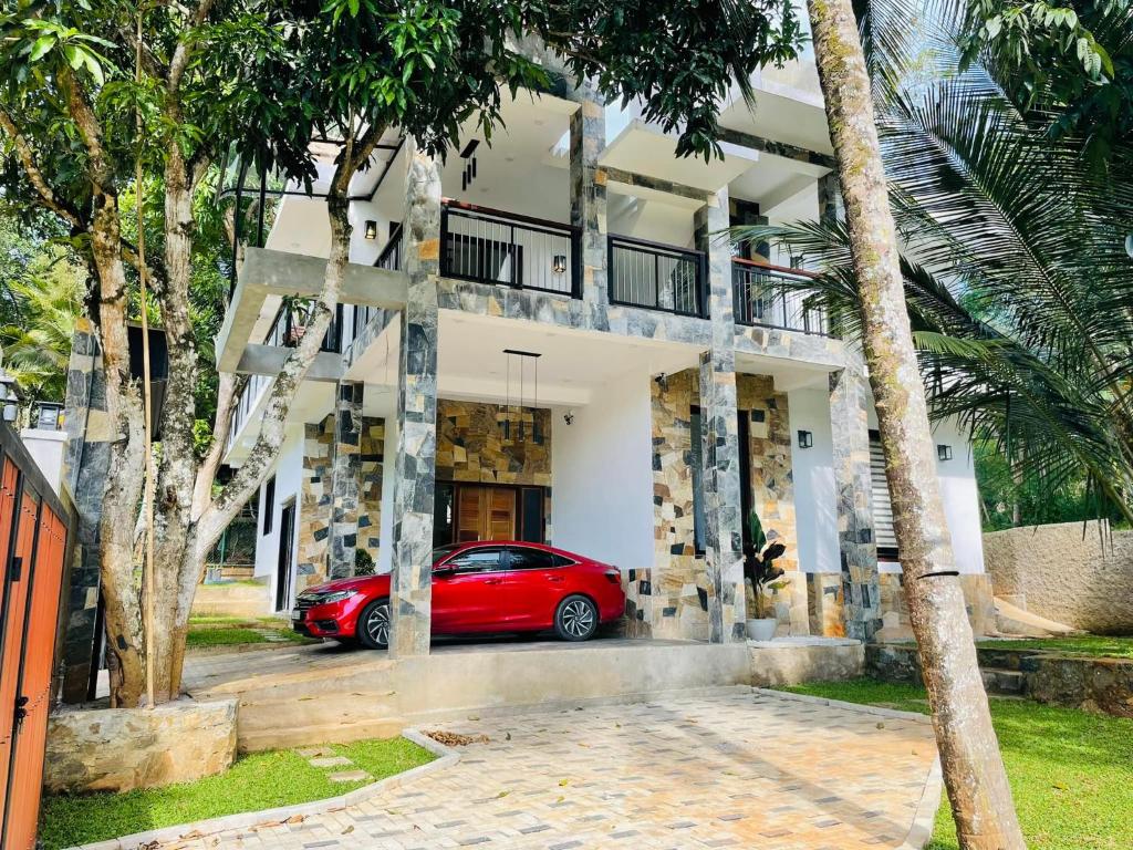 a red car parked in front of a building at RW Homestay in Wegala