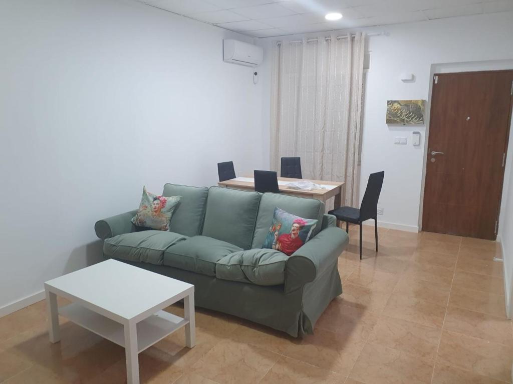 un soggiorno con un divano verde e un tavolo di Peaceful 4-6 person holiday home with patio, close to all amenities a Torrevieja
