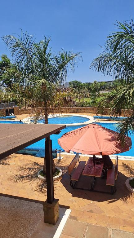 una mesa de picnic y sillas junto a una piscina en The Glass Loft, en Nairobi