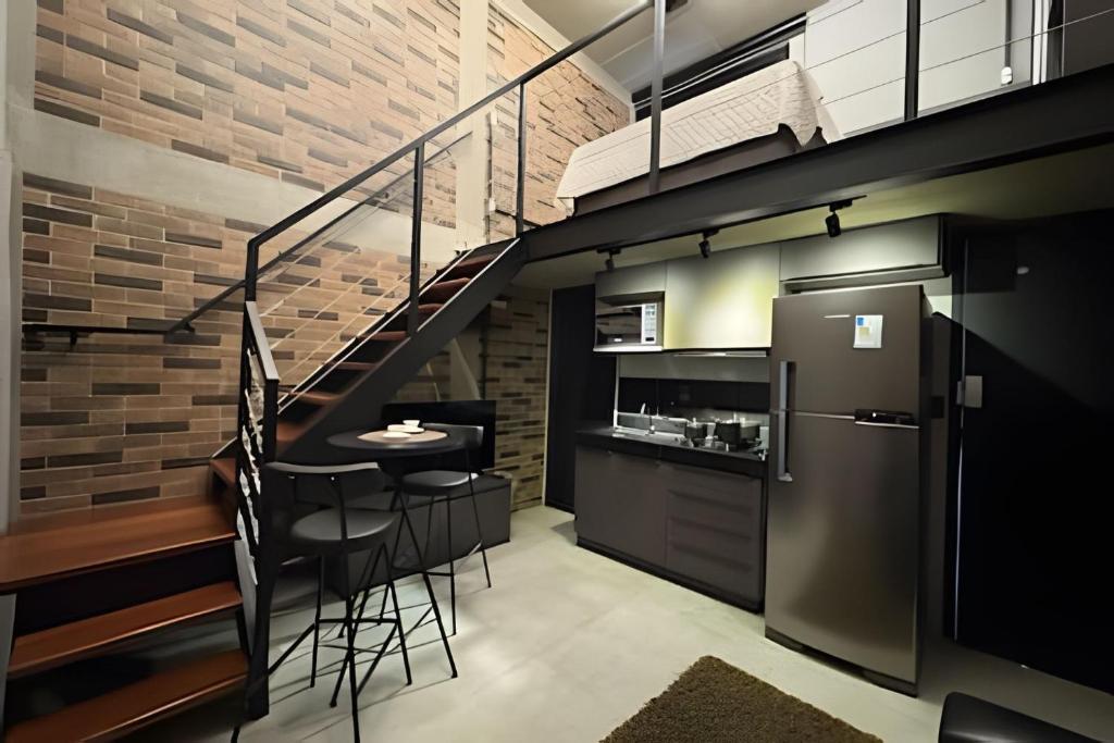 een loft keuken met een trap en een tafel bij Loft Encantador em Araxá in Araxá