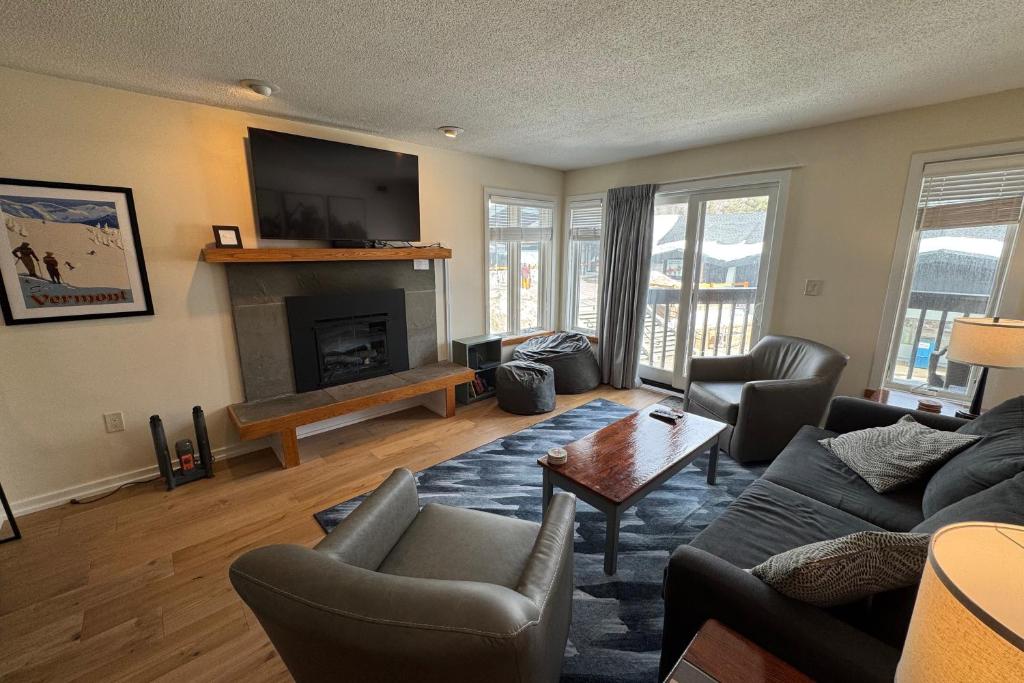 Una sala de estar con un sofá y una chimenea. en Okemo Mountain Lodge A208, en Ludlow