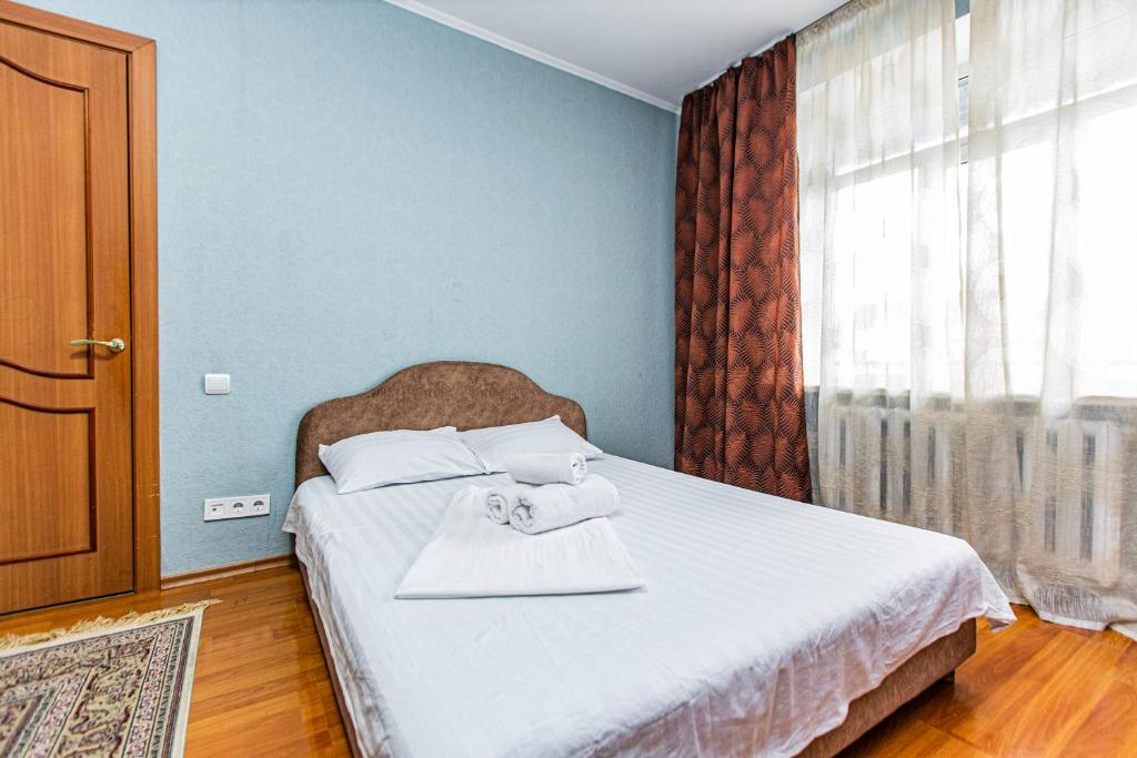 a bedroom with a bed with two towels on it at Однушка в центре Алматы, до Арбата 5 минут ходьбы #82 in Almaty