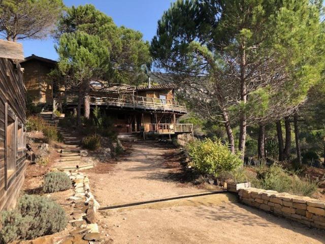 une grande maison avec une terrasse sur le côté. dans l'établissement le Sabel, à Mourèze