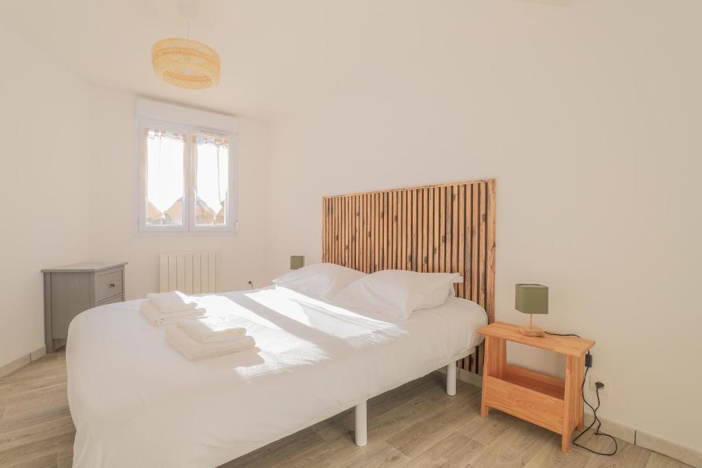 une chambre avec un lit blanc avec des oreillers blancs dans l'établissement Cosy en centre ville, à Amiens