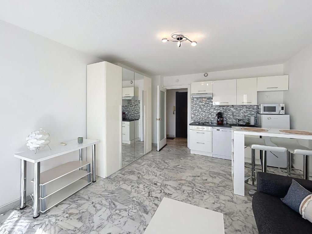 Il comprend une cuisine et un salon avec des placards blancs. dans l'établissement La Salangane, à Cannes