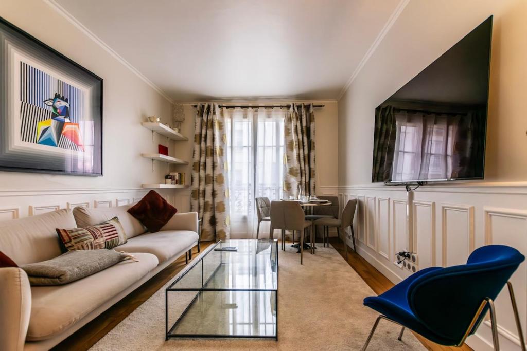 un salon avec un canapé et une table dans l'établissement Luxury Apartment Neuilly, à Neuilly-sur-Seine