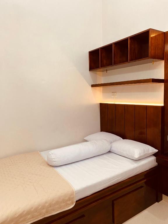 a bed with two pillows on it in a room at The Homey Coliving Lhokseumawe in Hago
