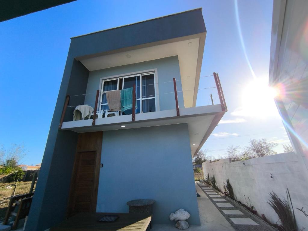 a house with a balcony with a table and chairs on it at Suíte Varanda Vist Mar Sonho do Pontal Arraial do Cabo in Arraial do Cabo