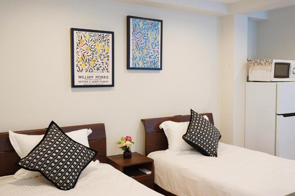 a hotel room with two beds and a microwave at 有朋ハウス 301 in Osaka