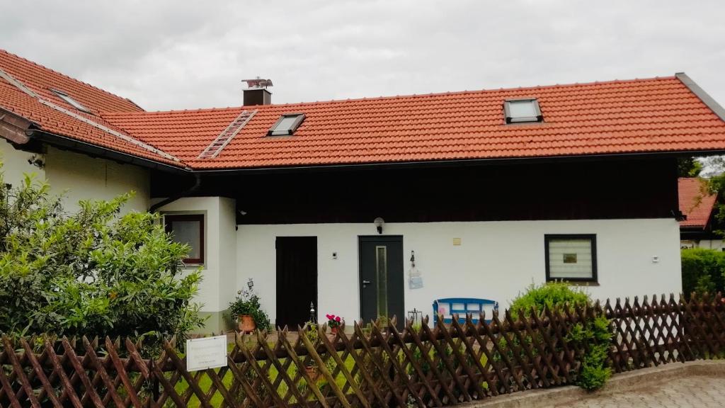 a small white house with an orange roof at Ferienwohnung Erika in Marquartstein