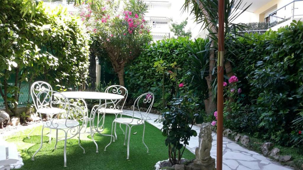 d'une terrasse avec une table et des chaises dans le jardin. dans l'établissement Appartement jardin, à Cannes