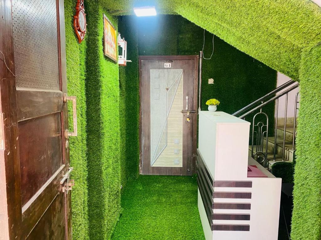 a hallway with a green wall with a door at Moonlight residency in Navi Mumbai