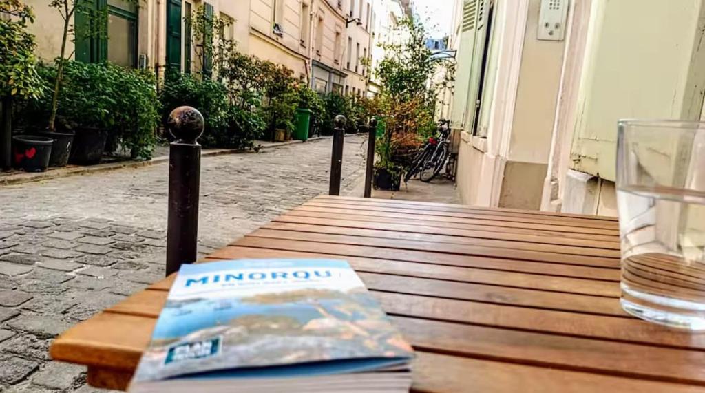 un livre assis sur une table en bois avec une boisson dans l'établissement Corner of Paradise, à Paris