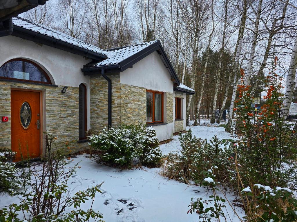a small house with snow on the ground at Pokoje gościnne na terenie Chojnowskiego Parku Krajobrazowego in Ławki