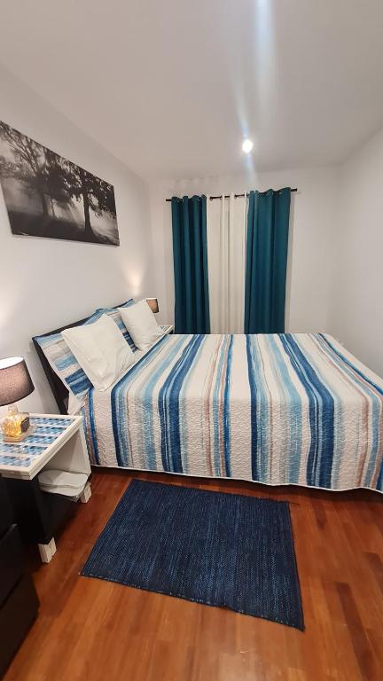 a bedroom with a bed and a table and a window at Maligueira Apartment in Leiria