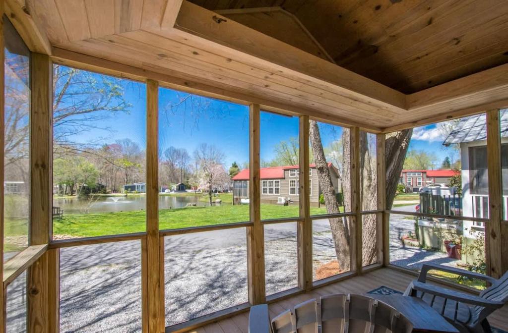 a screened in porch with a view of a yard at Lakeview 2BR Tiny Home near Trails and Bocce in Flat Rock