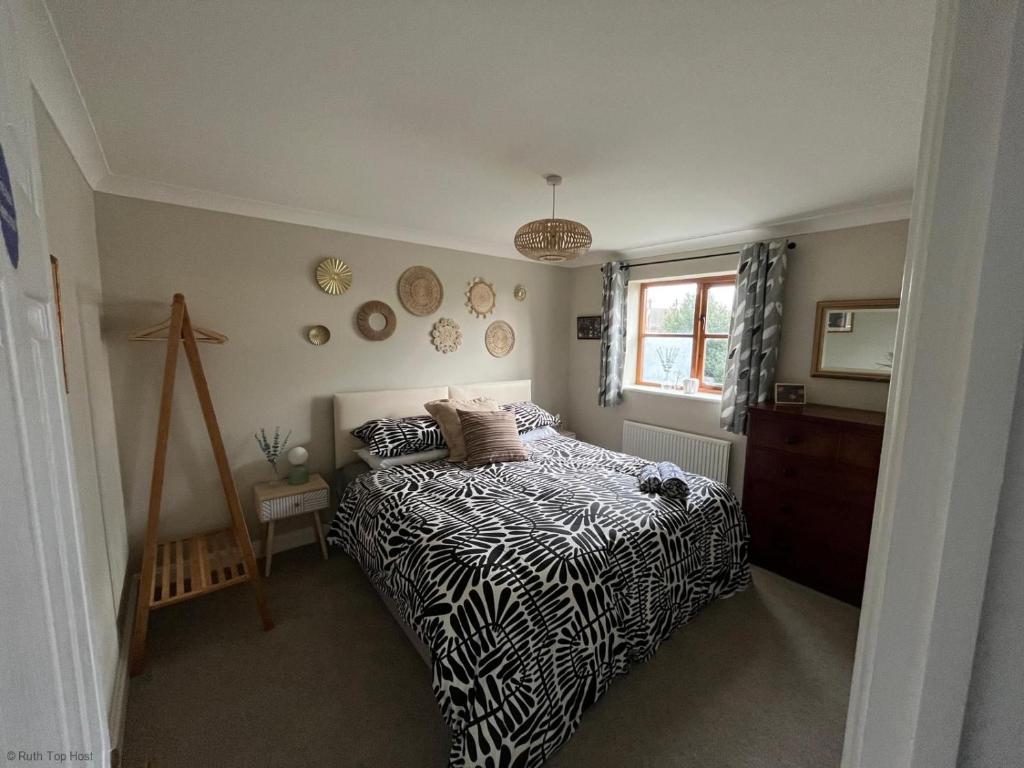 a bedroom with a black and white bed and a window at Spacious Village House near Oxford with Woodburner in Horspath