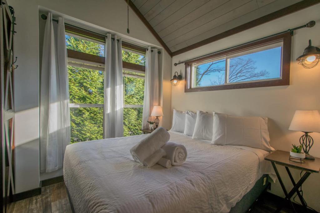 a bedroom with a bed with a chair on it at Gorgeous 1BR Tiny Home with Pool and Bocce in Flat Rock