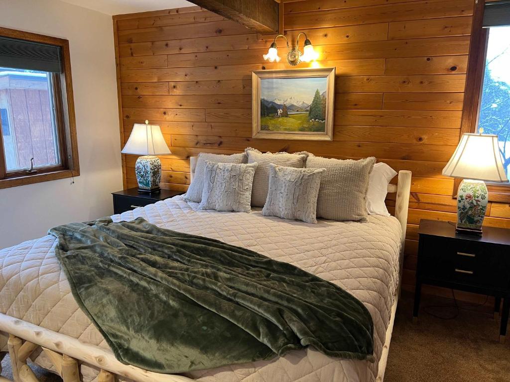 a bedroom with a bed with wooden walls and two lamps at Aspen Chalet 976 in Aspen